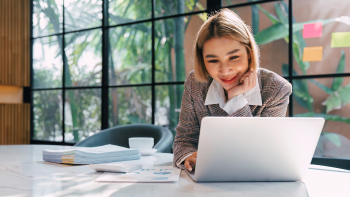 dame leest glimlachend op haar laptop