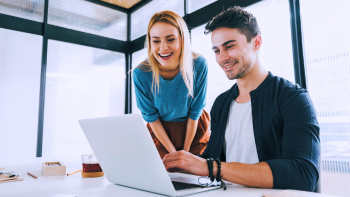 twee mensen kijken samen op een laptop